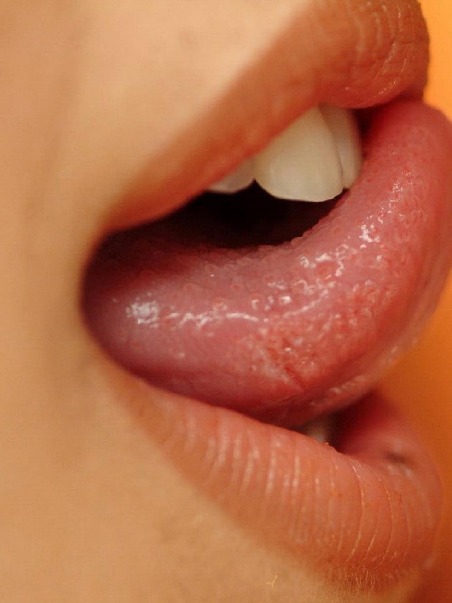 Красиво лижет языком. Женские губы. Страстный язык. Облизывание губ. Девушка с языком.
